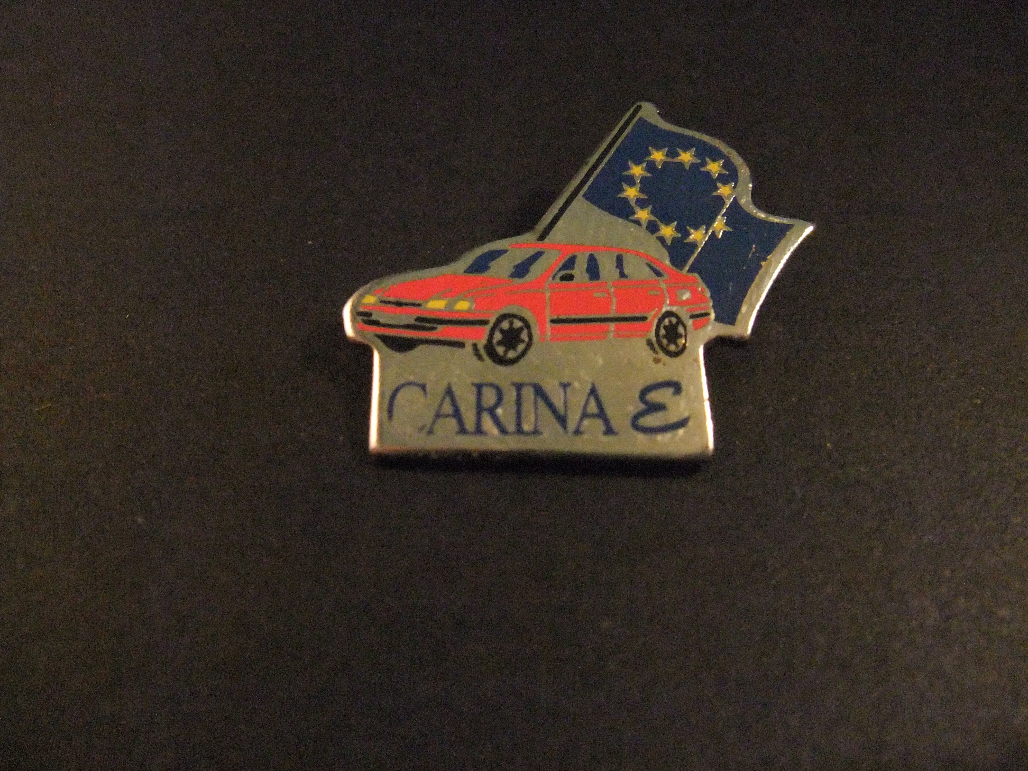 Toyota Carina compacte middenklasse personenauto, rood met Europese vlag